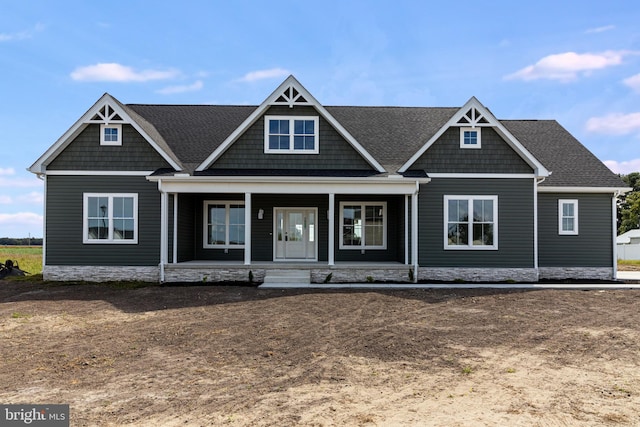 view of front of home featuring covered porch and roof with shingles