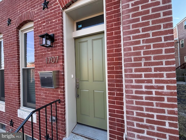 property entrance featuring brick siding