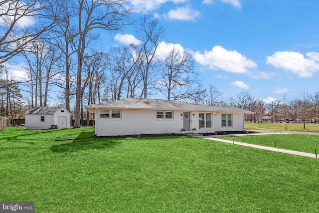 exterior space with a front yard, fence, an outdoor structure, and stucco siding