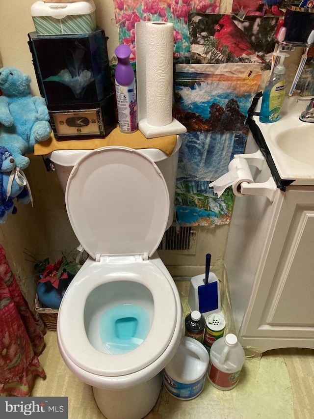 bathroom with toilet, vanity, and hardwood / wood-style floors