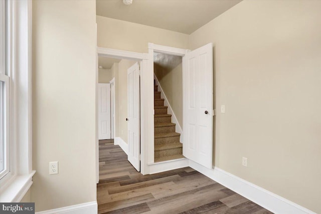 interior space with stairway, wood finished floors, and baseboards