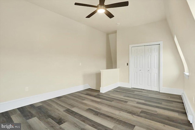 spare room featuring dark wood-style floors, ceiling fan, a baseboard radiator, and baseboards