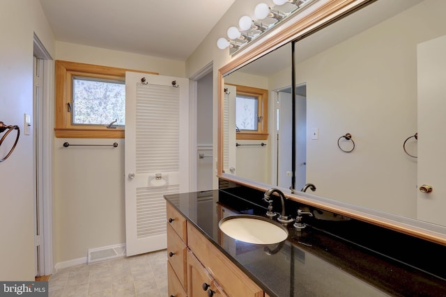 bathroom featuring visible vents, vanity, and baseboards