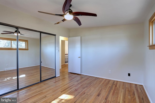 unfurnished bedroom featuring visible vents, ceiling fan, baseboards, light wood-type flooring, and a closet