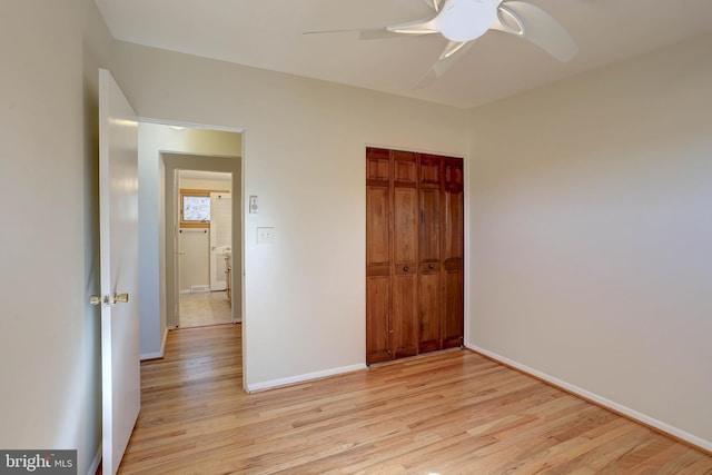 unfurnished bedroom with light wood-style flooring, baseboards, a closet, and ceiling fan