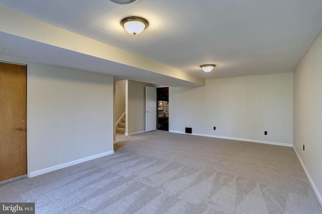 finished basement with stairway, baseboards, and carpet floors