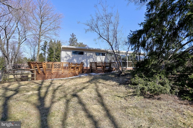 back of property featuring a deck and fence