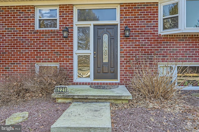 view of exterior entry featuring brick siding