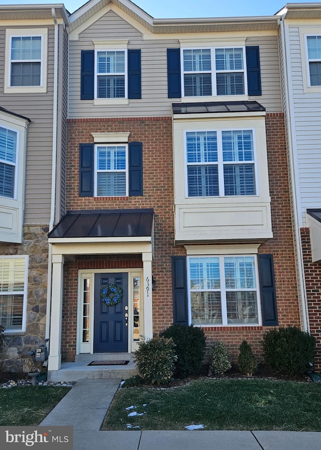 multi unit property with a standing seam roof, brick siding, and metal roof