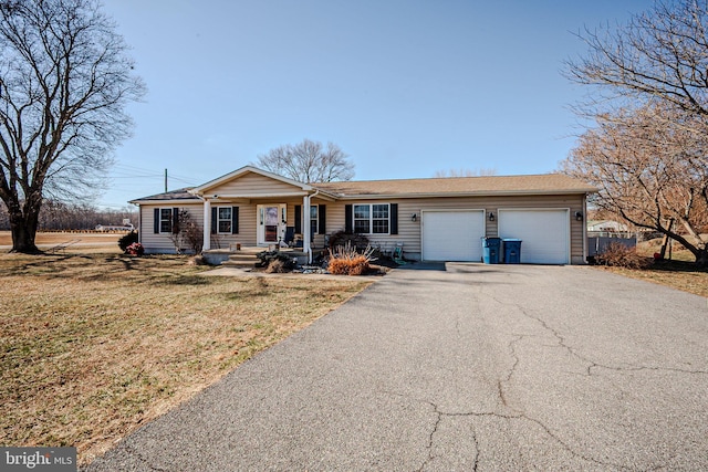 ranch-style house featuring driveway, a garage, and a front yard