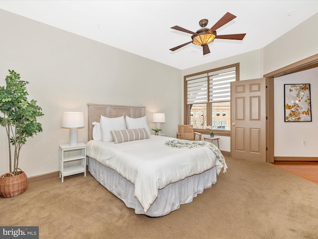 carpeted bedroom featuring baseboards and a ceiling fan