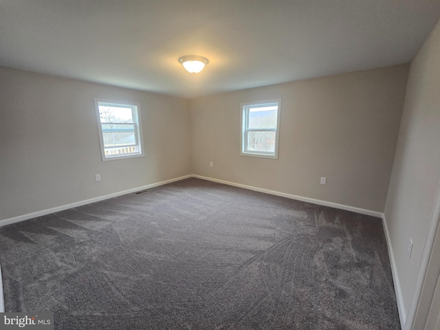 carpeted empty room featuring a wealth of natural light