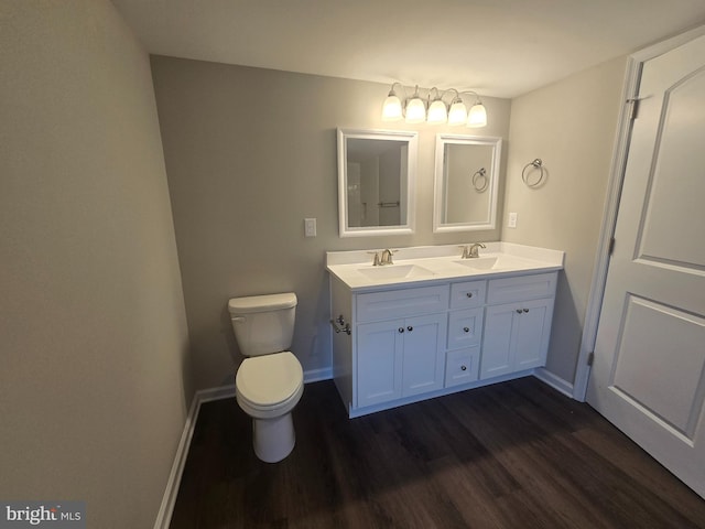 bathroom with toilet, vanity, and hardwood / wood-style floors