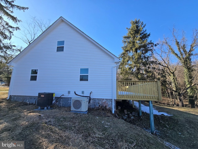 view of home's exterior with a deck, central AC unit, and ac unit