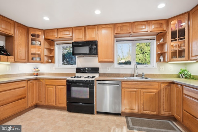 kitchen with a sink, black microwave, range with gas stovetop, stainless steel dishwasher, and open shelves