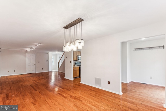 interior space with light wood-type flooring, baseboards, and visible vents