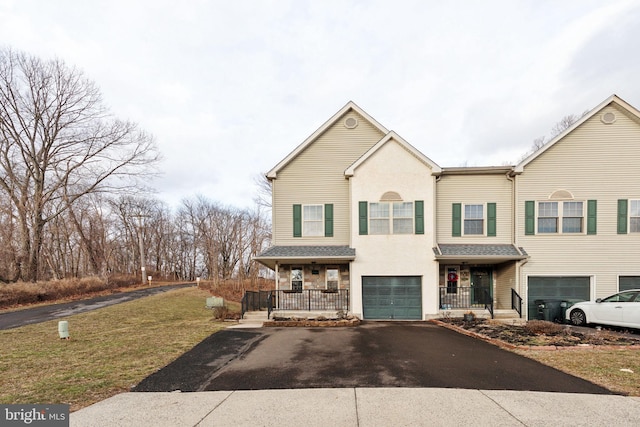 multi unit property with a porch, aphalt driveway, a garage, stucco siding, and a front yard