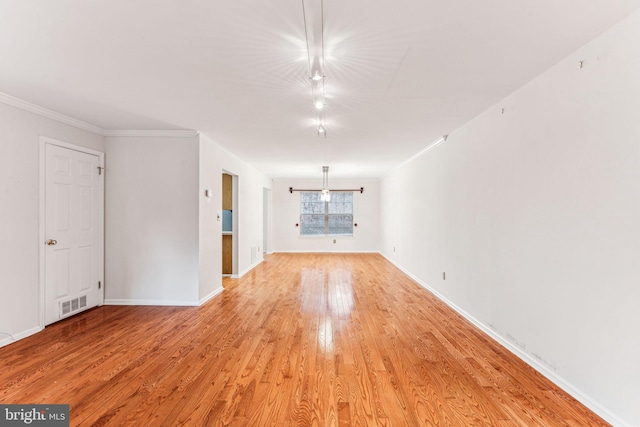 unfurnished room featuring baseboards, visible vents, crown molding, and light wood finished floors