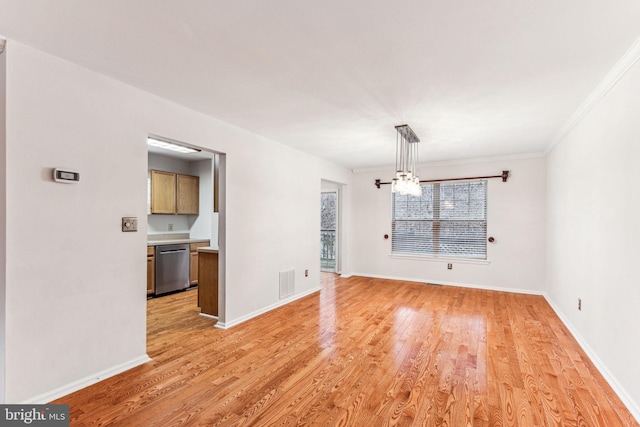 unfurnished dining area with crown molding, visible vents, light wood-style flooring, an inviting chandelier, and baseboards