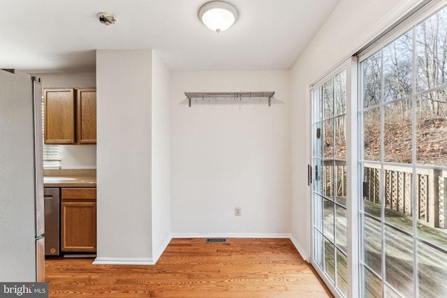 interior space featuring light wood-type flooring, visible vents, and baseboards