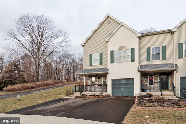 view of property with driveway, roof with shingles, an attached garage, a porch, and stucco siding