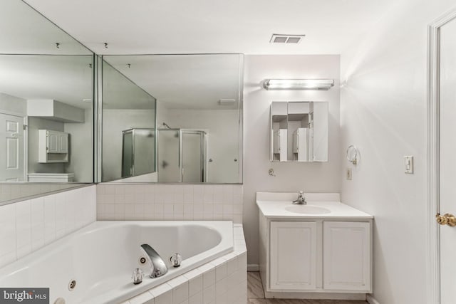 full bath with visible vents, a jetted tub, a shower stall, and vanity