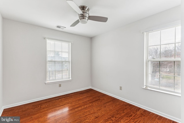 unfurnished room with a ceiling fan, baseboards, visible vents, and wood finished floors