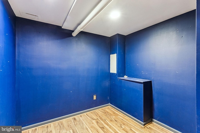 spare room featuring wood finished floors and baseboards