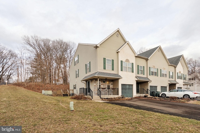 multi unit property with a garage, covered porch, driveway, and a front yard