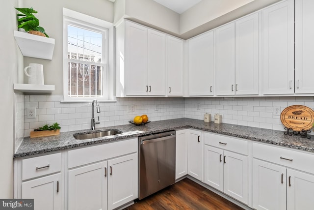 kitchen featuring dark stone countertops, stainless steel dishwasher, white cabinetry, open shelves, and a sink