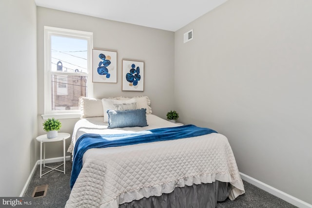 bedroom with dark carpet, visible vents, and baseboards