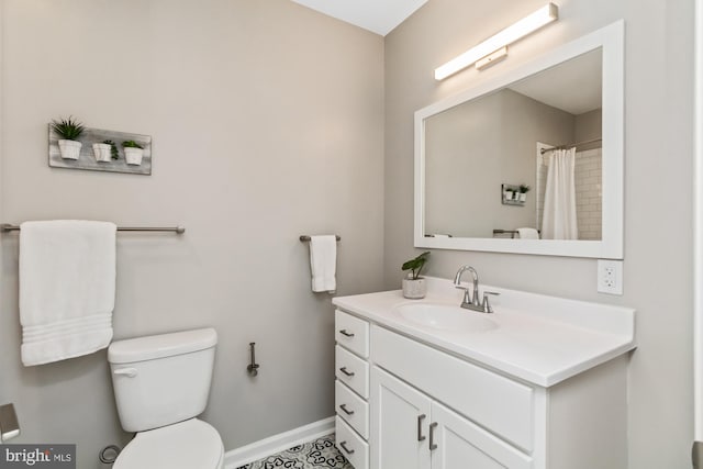 bathroom featuring baseboards, vanity, and toilet