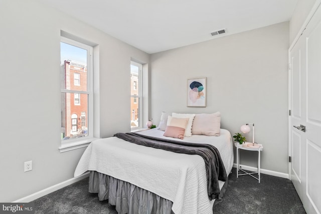 bedroom featuring visible vents, dark carpet, and baseboards