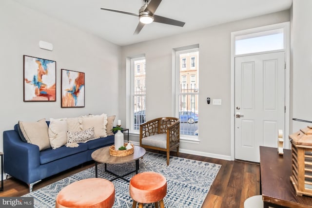 living room with dark wood-style floors, ceiling fan, and baseboards