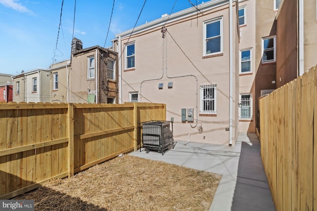 back of house featuring a residential view, a patio area, a fenced backyard, and stucco siding