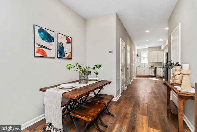 hallway with dark wood-style floors, recessed lighting, visible vents, and baseboards