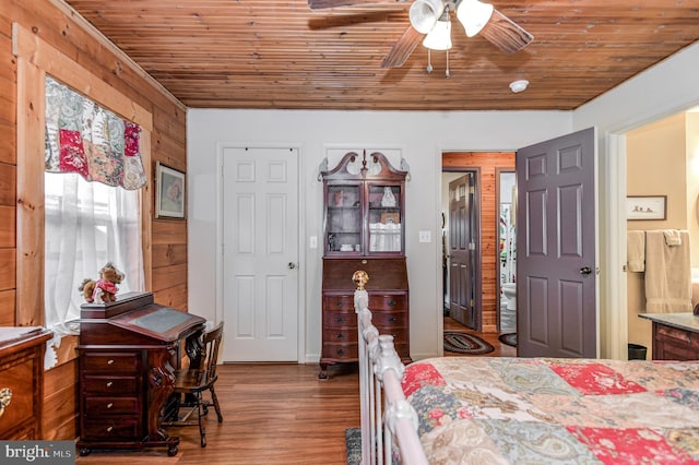 bedroom with hardwood / wood-style flooring, ceiling fan, wooden ceiling, and wooden walls