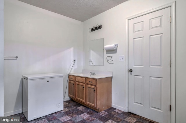 bathroom featuring a textured ceiling and vanity