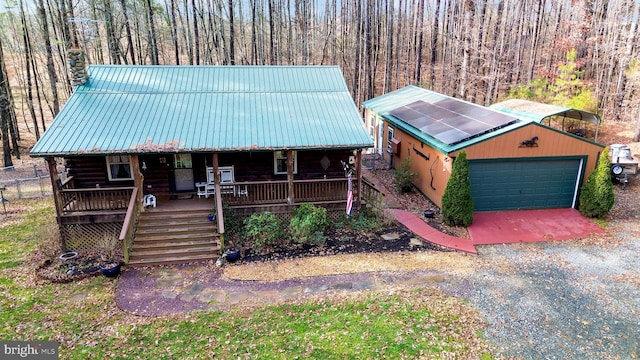 cabin with a garage, an outbuilding, and a porch