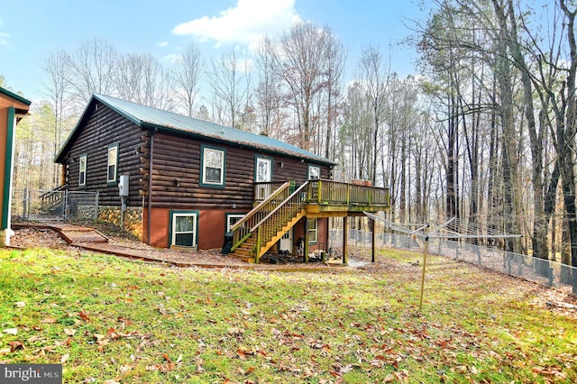 rear view of house with a yard and a wooden deck