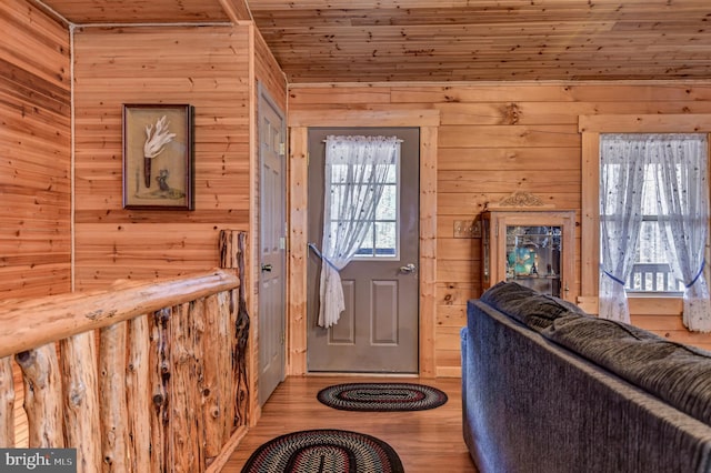 foyer featuring wooden ceiling, wood walls, and light hardwood / wood-style flooring