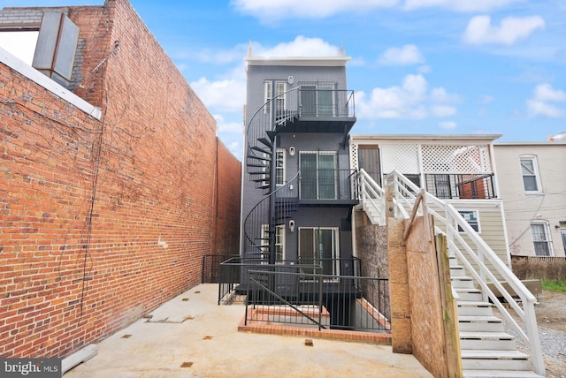 view of front of home with stairs and brick siding