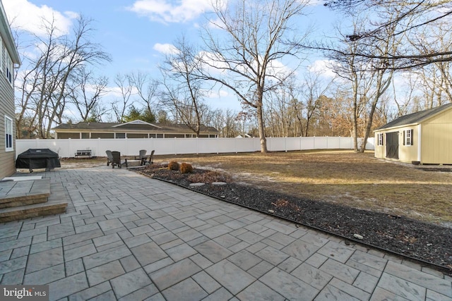 view of patio featuring an outbuilding and a grill