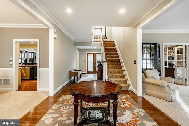 foyer featuring visible vents, stairway, ornamental molding, wood finished floors, and french doors