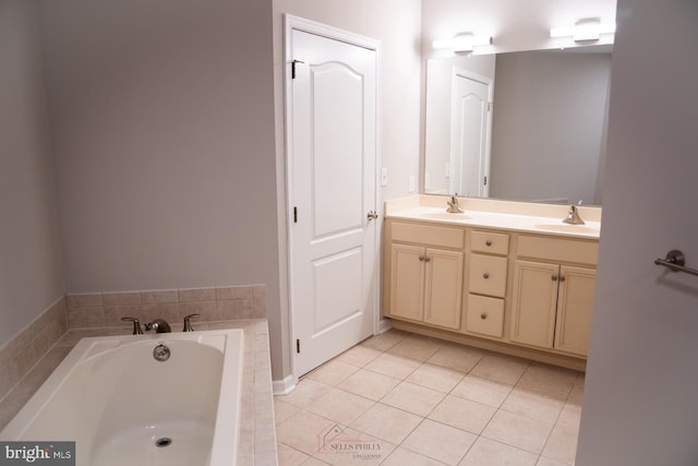 bathroom featuring vanity, tile patterned flooring, and tiled tub