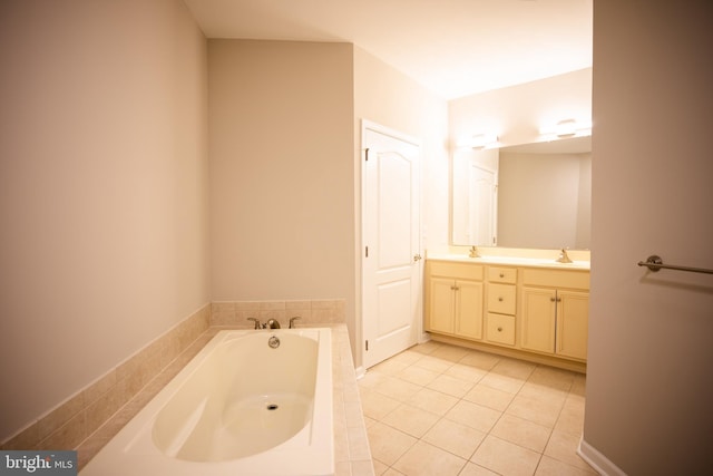 bathroom featuring double vanity, a garden tub, tile patterned floors, and a sink