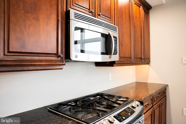 kitchen featuring appliances with stainless steel finishes and dark stone countertops