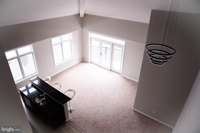 bonus room featuring light carpet and vaulted ceiling with beams