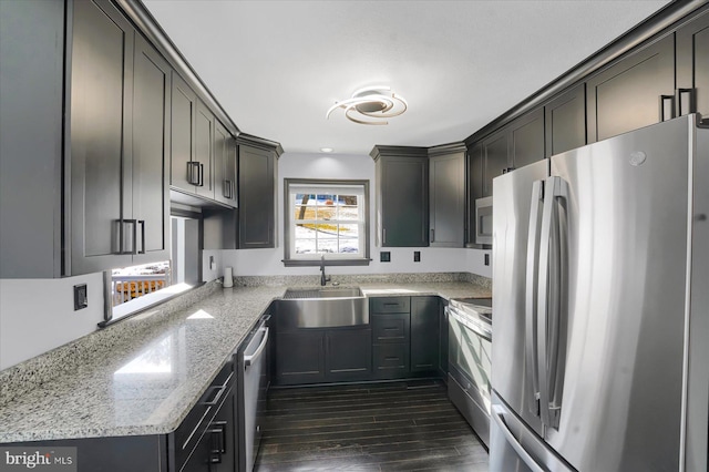 kitchen featuring appliances with stainless steel finishes, sink, dark hardwood / wood-style flooring, and light stone countertops