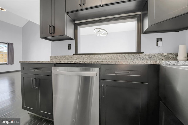 kitchen featuring dark hardwood / wood-style floors, light stone countertops, and stainless steel dishwasher